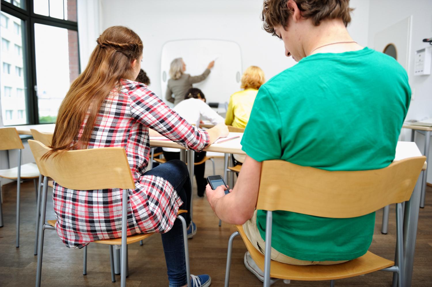 A student texting on his smartphone in the classroom