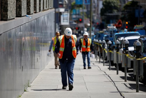A worker with Pacific Gas and Electric (PG&E) walks on a street.