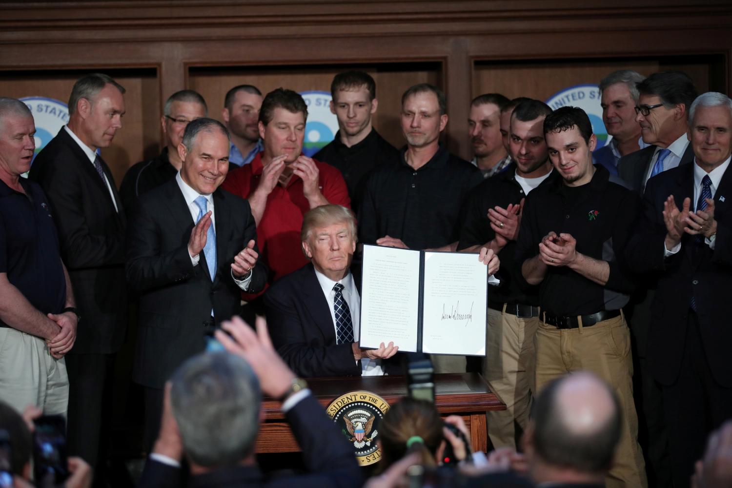 U.S. President Donald Trump holds up an executive order on "energy independence," eliminating Obama-era climate change regulations, during a signing ceremony at the Environmental Protection Agency (EPA) headquarters in Washington, U.S., March 28, 2017. REUTERS/Carlos Barria - RTX333NH