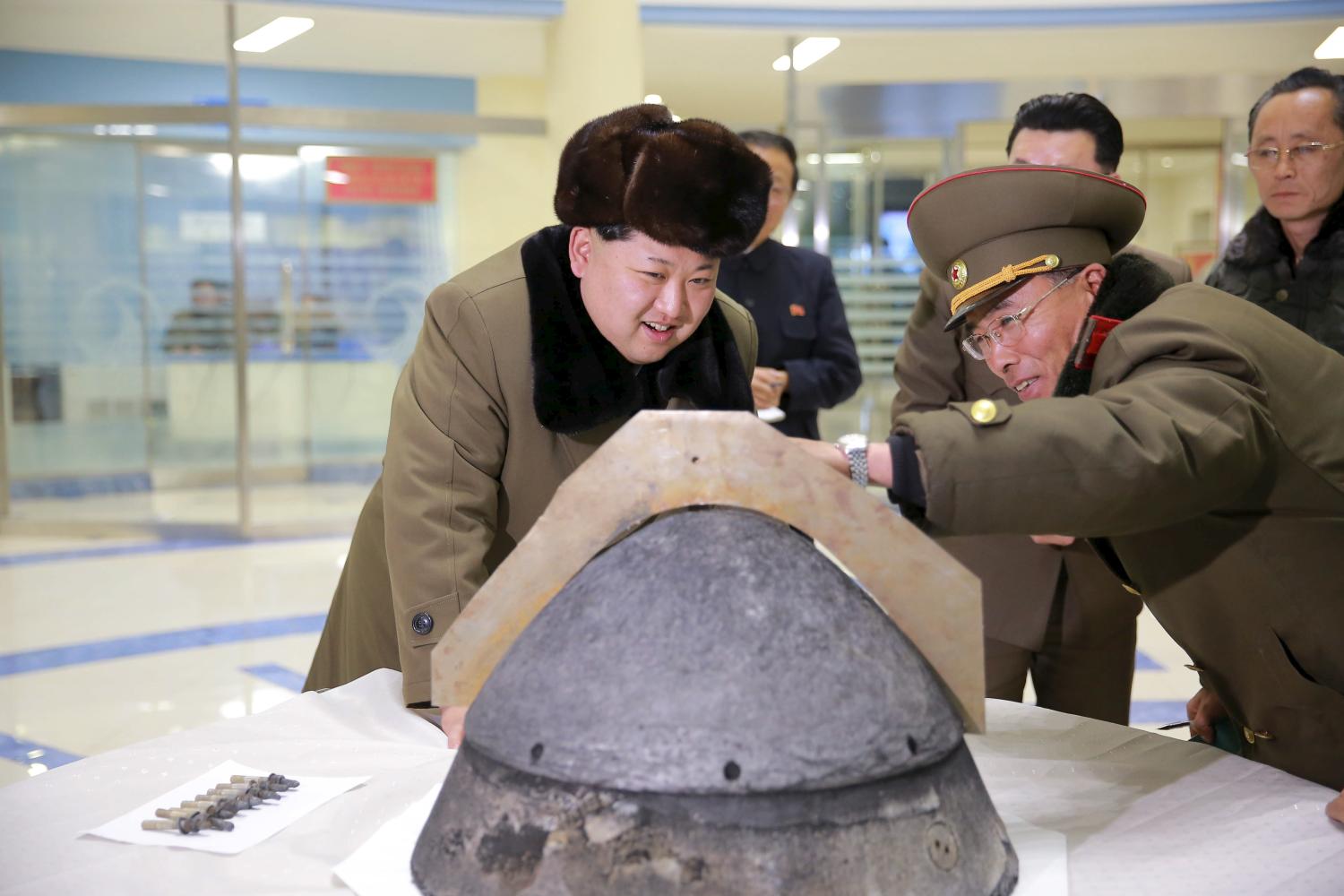 North Korean leader Kim Jong Un looks at a rocket warhead tip after a simulated test of atmospheric re-entry of a ballistic missile