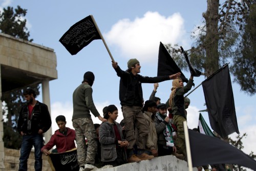 Protesters carry Nusra Front flags and shout slogans during an anti-government protest after Friday prayers in the town of Marat Numan in Idlib province, Syria, March 11, 2016. REUTERS/Khalil Ashawi - RTSAD3R