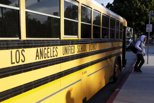 A student exits a bus as he arrives at Venice High School in Los Angeles, California