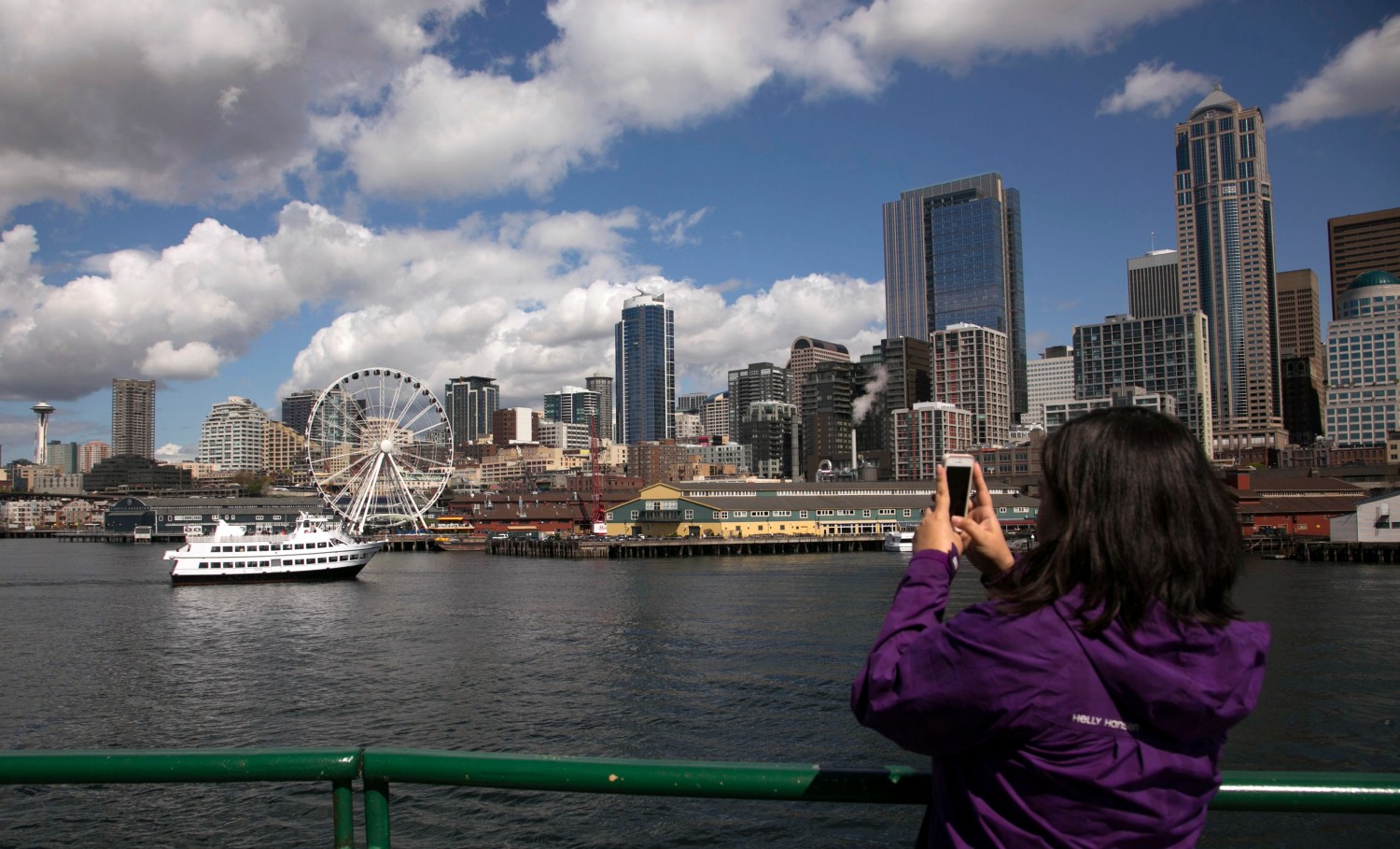 A passenger on the Bainbridge Island Ferry takes a cell phone photo of the skyline in Seattle, Washington April 9, 2014. Picture taken April 9, 2014. To match story TRAVEL-SEATTLE/ REUTERS/Jason Redmond (UNITED STATES - Tags: CITYSCAPE TRAVEL)