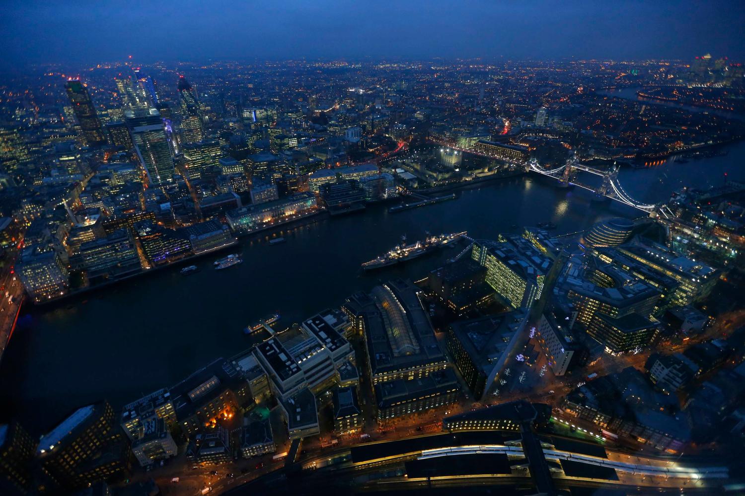 Tower Bridge and the museum warship HMS Belfast are seen at dusk in an aerial photograph from The View gallery at the Shard, western Europe's tallest building, in London