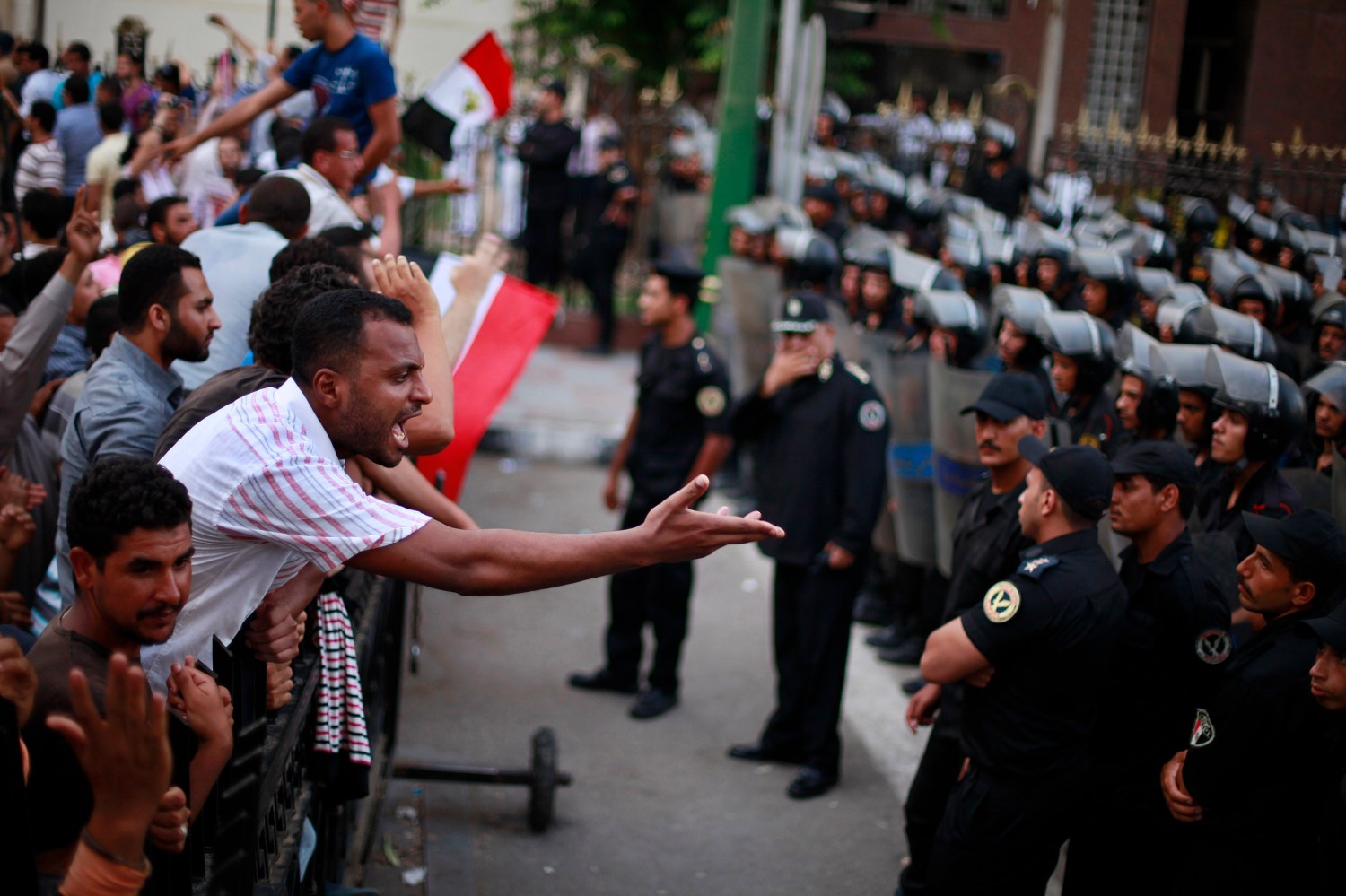 Protester shouts at police as they guard during a protest against the military council outside Egypt's parliament in Cairo