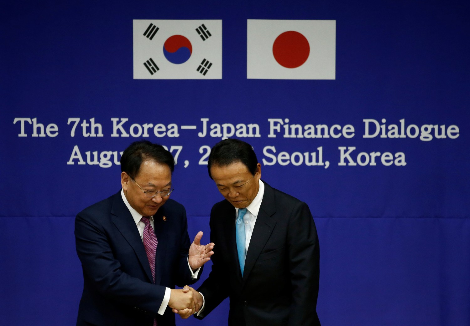 South Korean Finance Minister Yoo Il-ho shakes hands with his Japanese counterpart Taro Aso during the 7th Korea-Japan Finance Dialogue at the Government Complex in Seoul