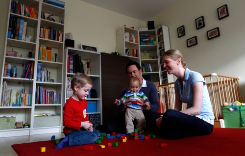 Baby Leonard plays with his brother and parents in living-room in Ismaning