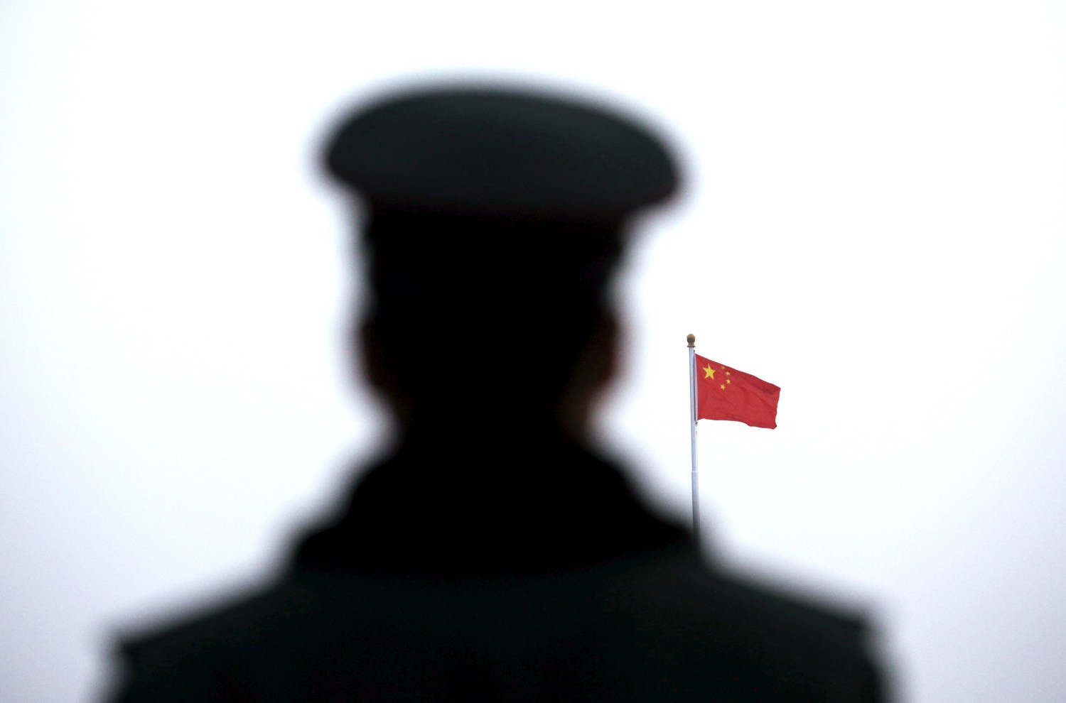 A paramilitary policeman watches a flag-raising ceremony at Tiananmen Square ahead of the opening session of the National People's Congress in Beijing, China