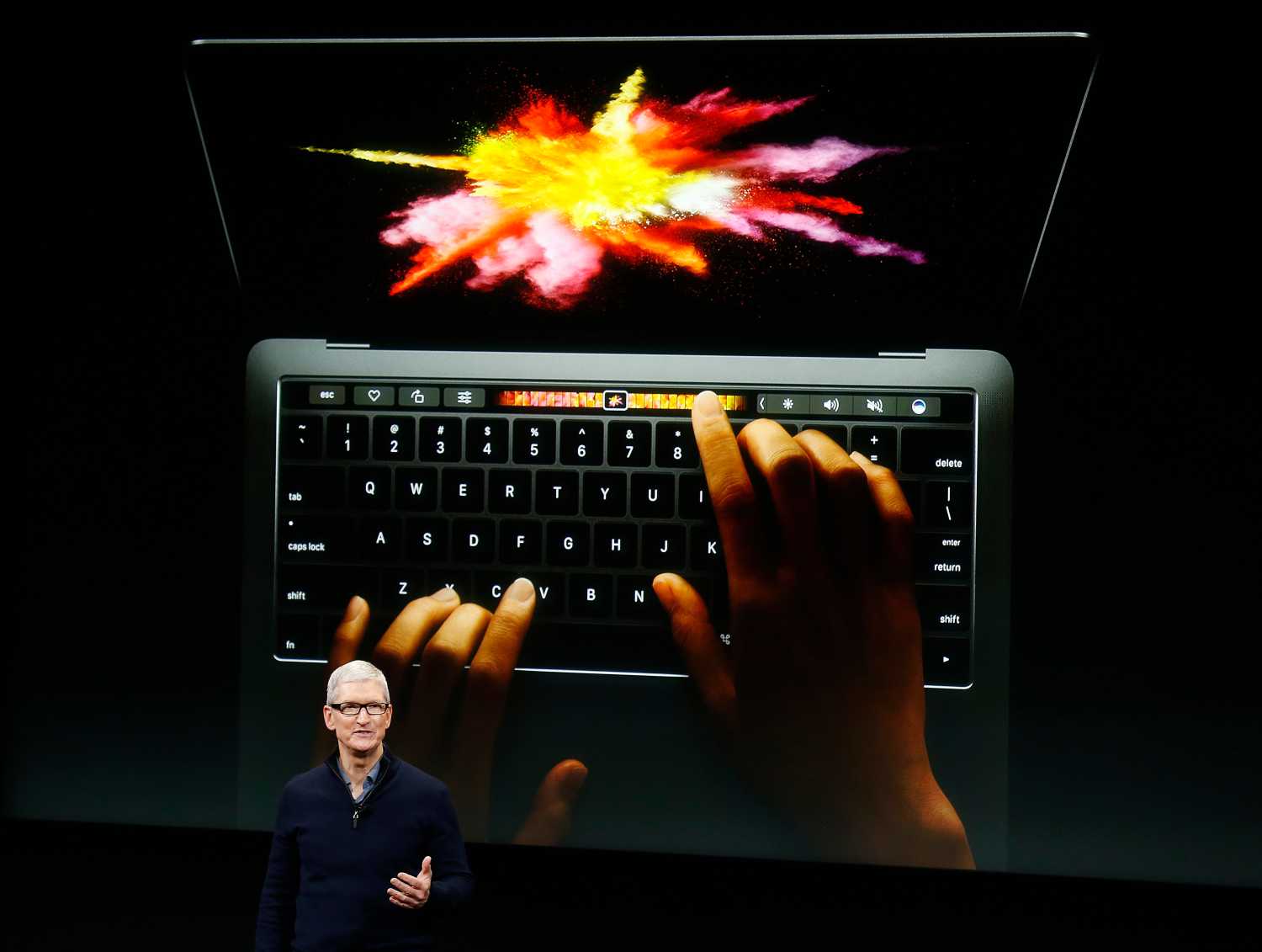Apple CEO Tim Cook speaks under a graphic of the new MacBook Pro during an Apple media event in Cupertino
