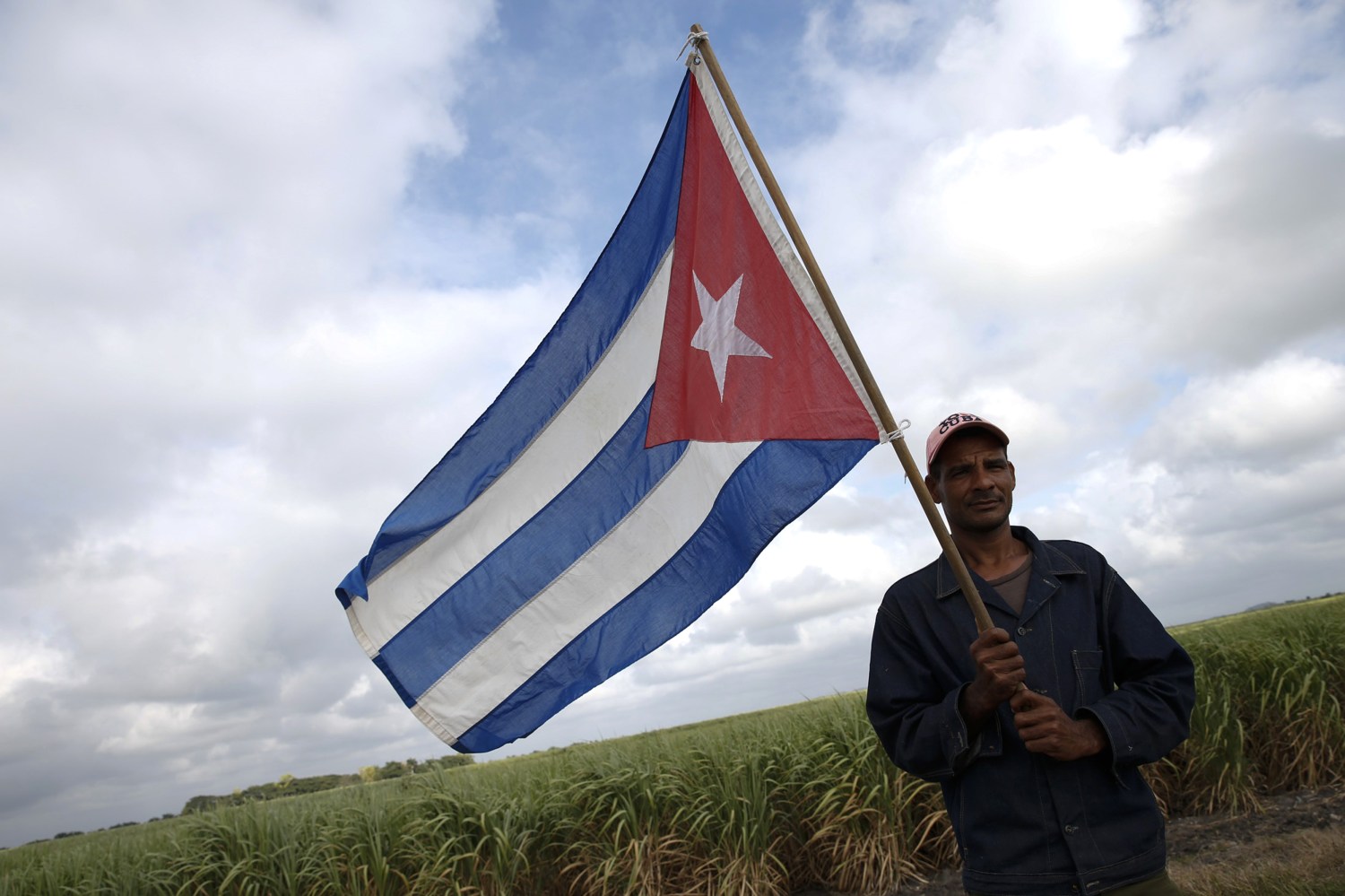 A man carries a Cuban flag as he waits for the caravan carrying Fidel Castro's ashes in El Maja