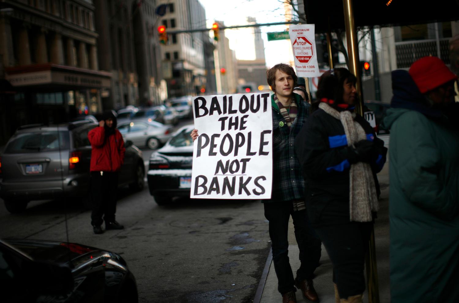 A man joins a protest organized by a group called "Moratorium Now" in front of the Bank of America building in downtown Detroit