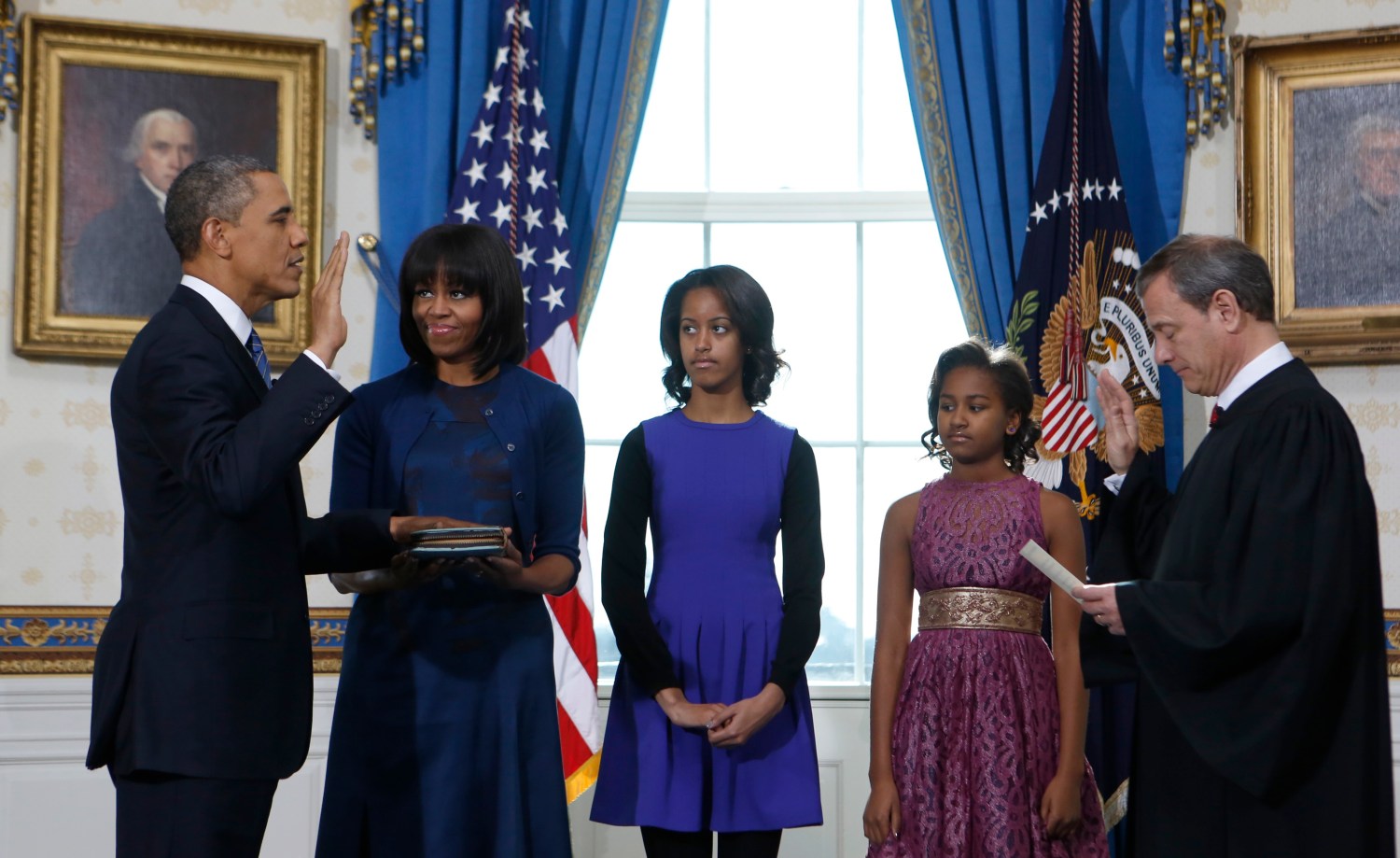 U.S. President Obama takes the oath of office from U.S. Supreme Court Chief Justice Roberts (R) as first lady Michelle Obama holds the bible and daughters Malia and Sasha look on in the Blue Room of the White House in Washington