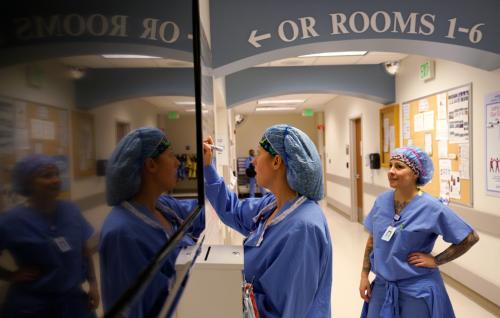 Operating room Charge Nurse Bridgett Pacheco writes on the daily O.R. schedule as O.R. Technician Liz Keating watches at Littleton Adventist Hospital, part of Centura Health in Littleton