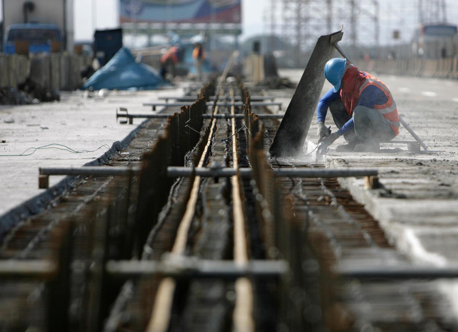 A labourer works on a highway bridge in Manila
