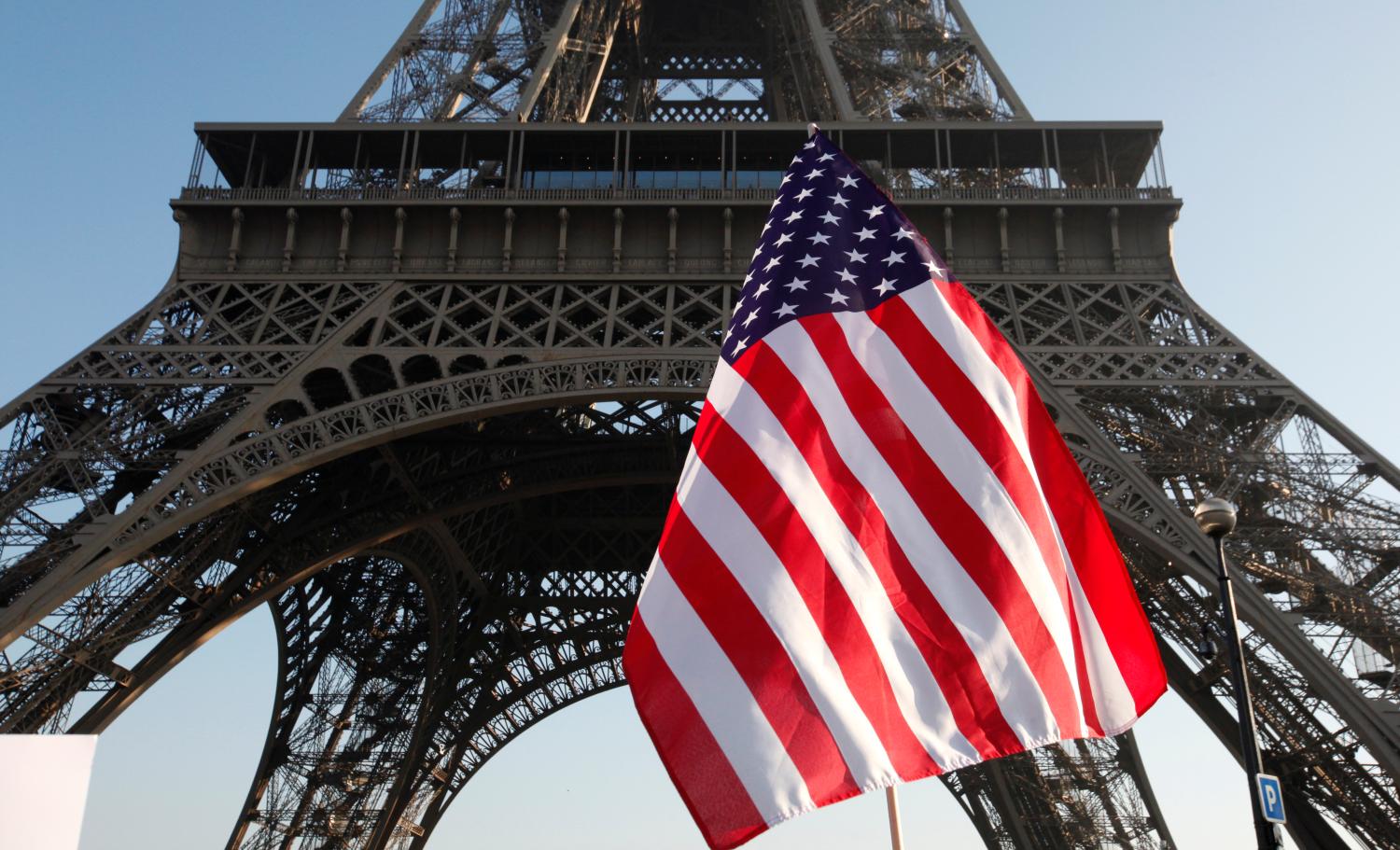 An American flag is seen during a Women's March near the Eiffel Tower in Paris