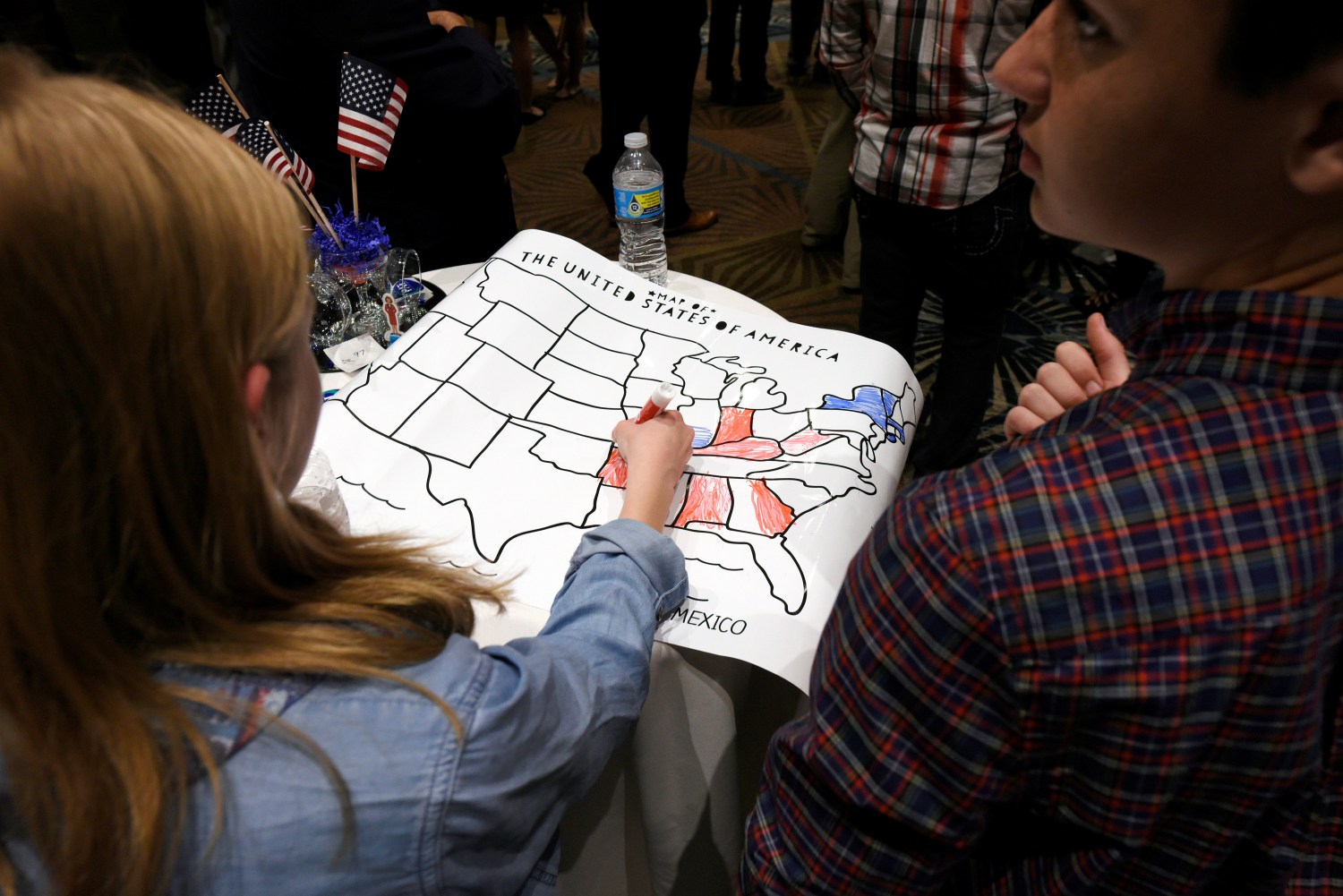 A girls colors an electoral map of the United States in either red or blue as returns are announced for the U.S. general election at Republican Governor Pat McCrory's election-night party in Raleigh, North Carolina, U.S.