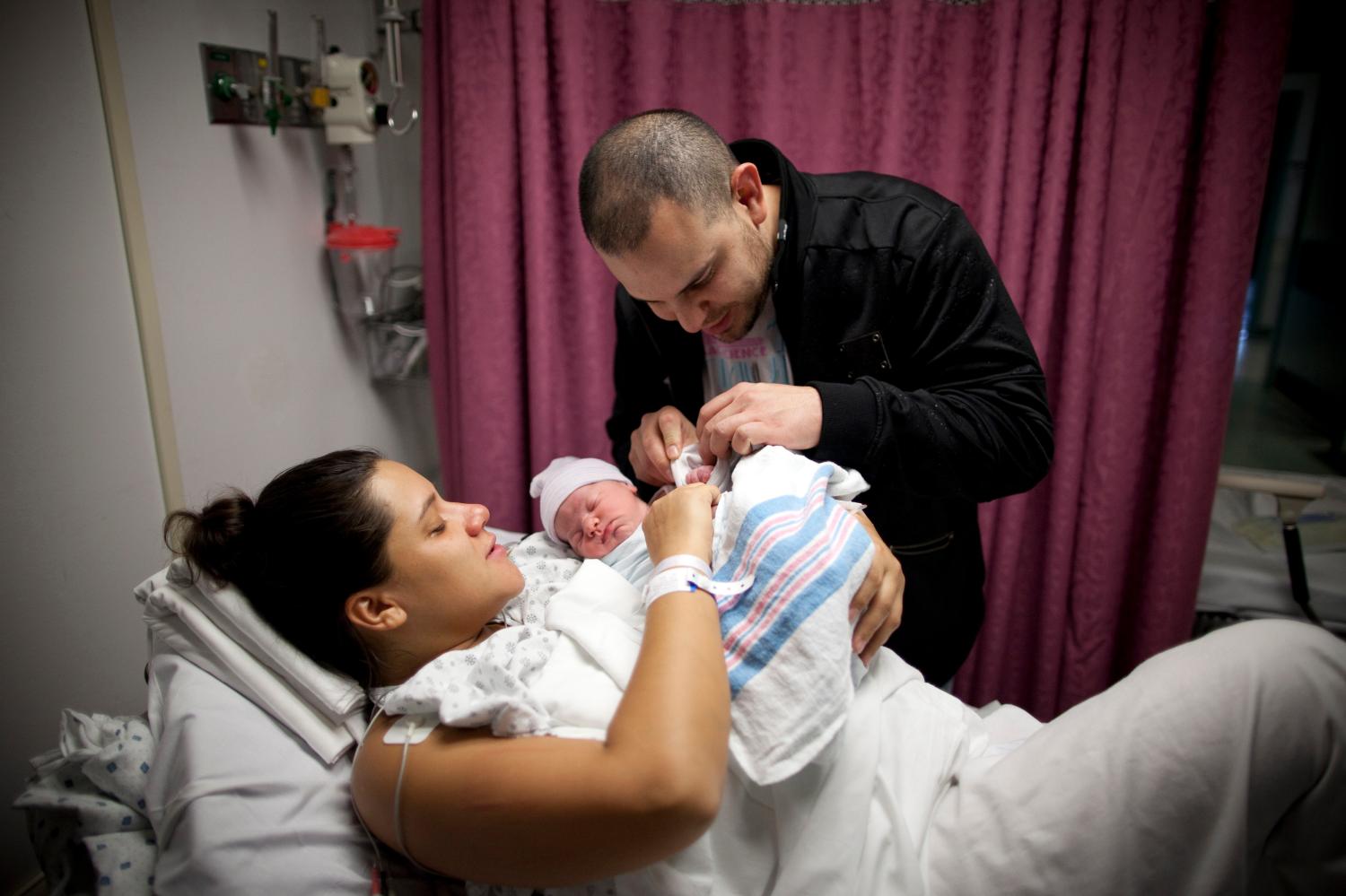 Parents look at their daughter Makenzie for the first time since she was born at 10:25am at Wyckoff Heights Medical Center in the Brooklyn borough of New York