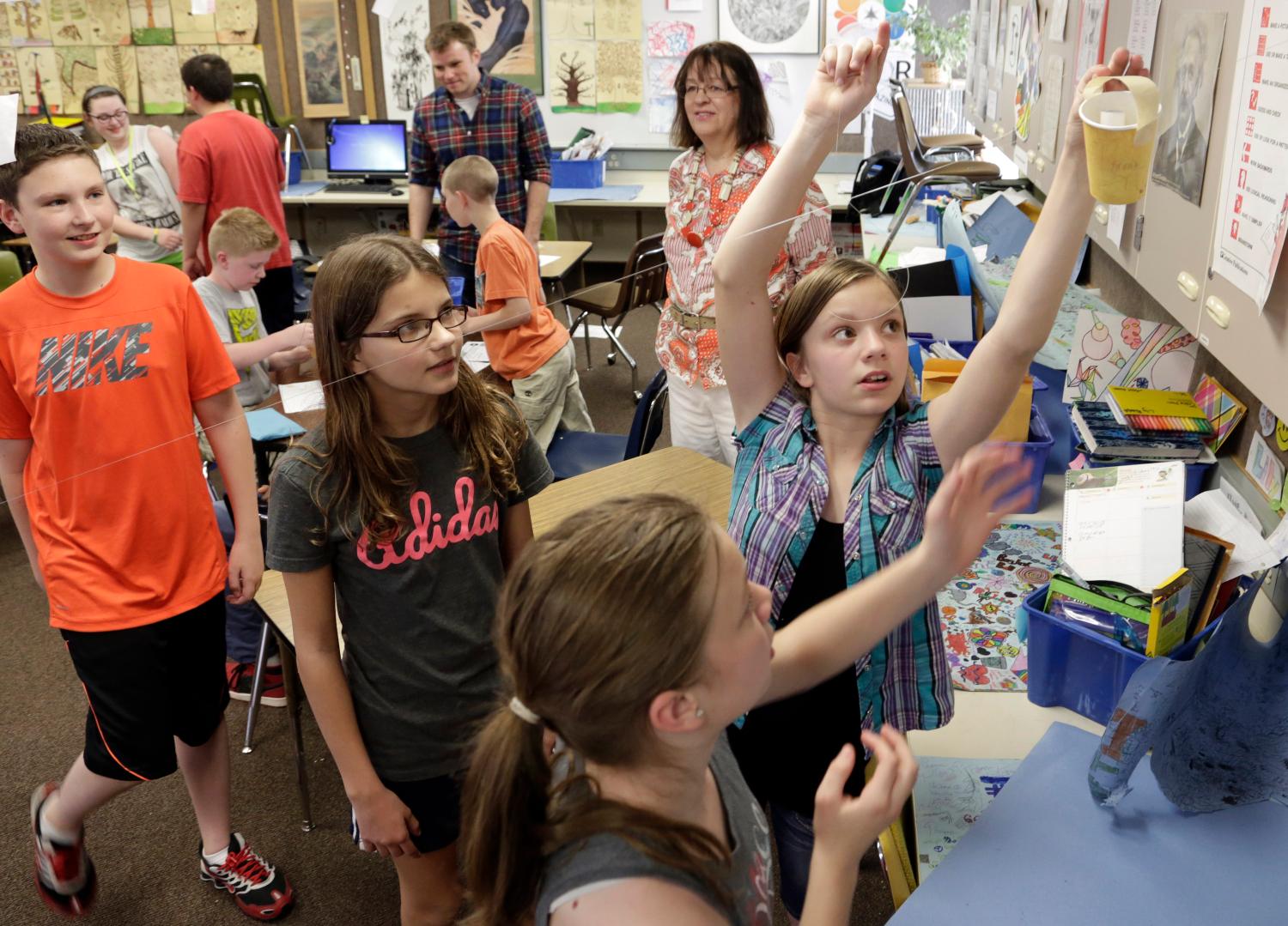 Sixth-grade student Hames tries out her group's design for a cup that drops a marble on a target via a zip-line as Boeing employees mentor students at after-school Science Technology Engineering and Math academy, in Covington, Washington