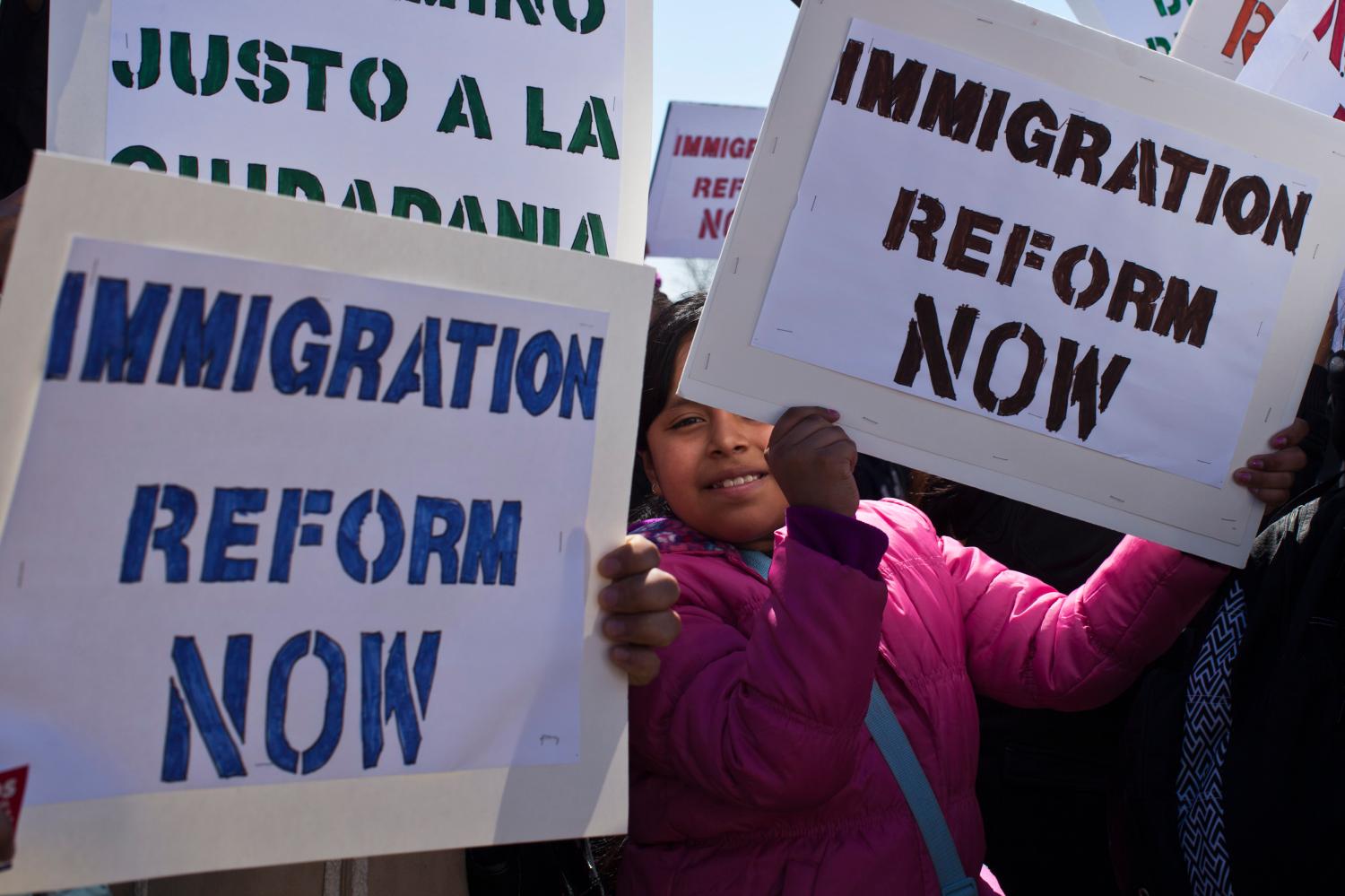 A girl holds up a banner while people take part in a rally to demand that Congress fix the broken immigration system at Liberty State Park in Jersey City, New Jersey