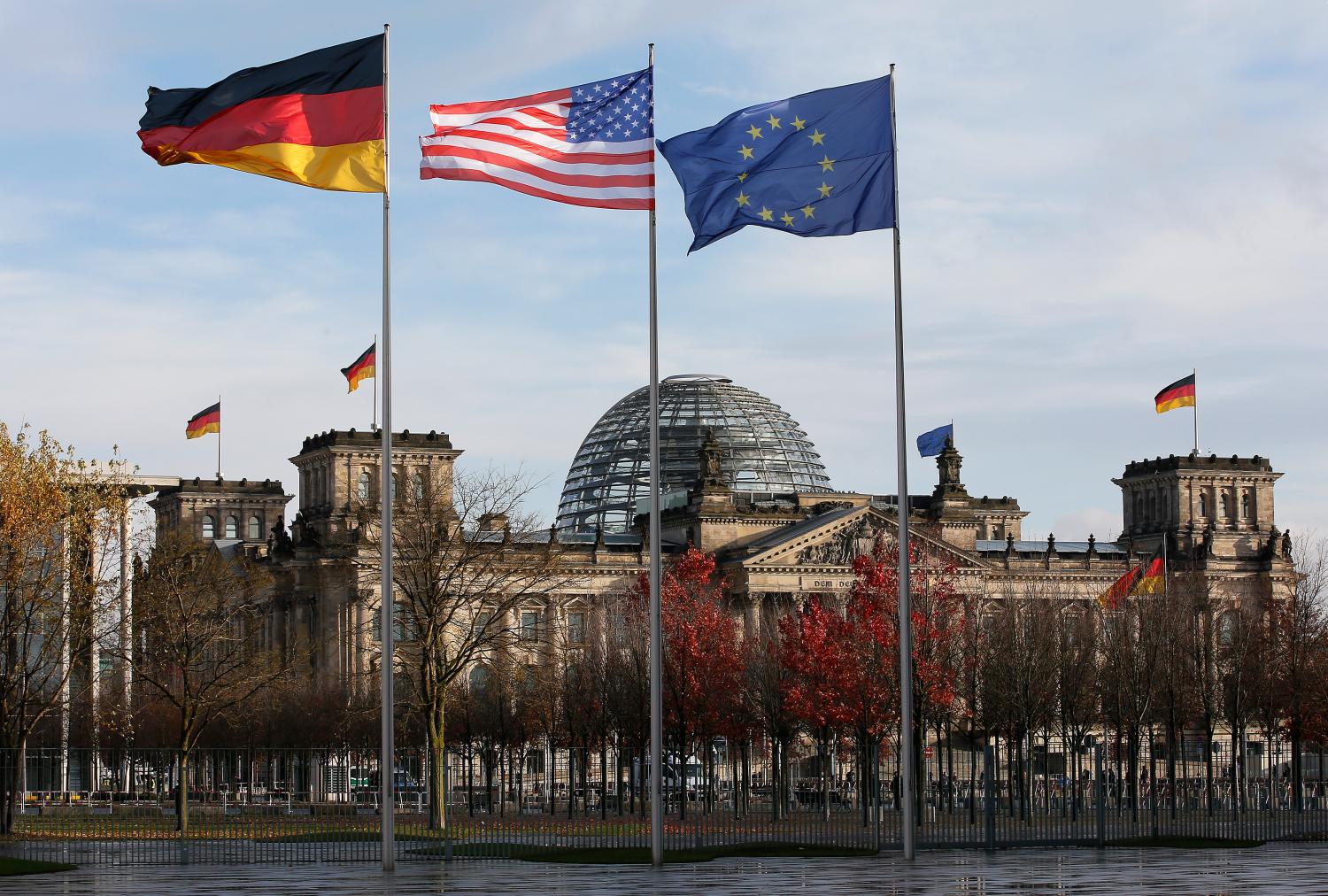 German, U.S. and EU flags fly in front of the Reichstag building ahead of the meeting between U.S. President Obama and German Chancellor Merkel in Berlin