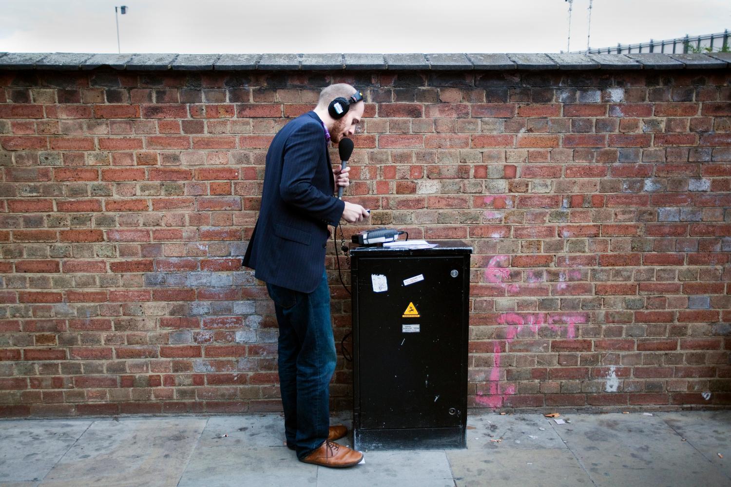 A radio reporter speaks into a microphone during a demonstration