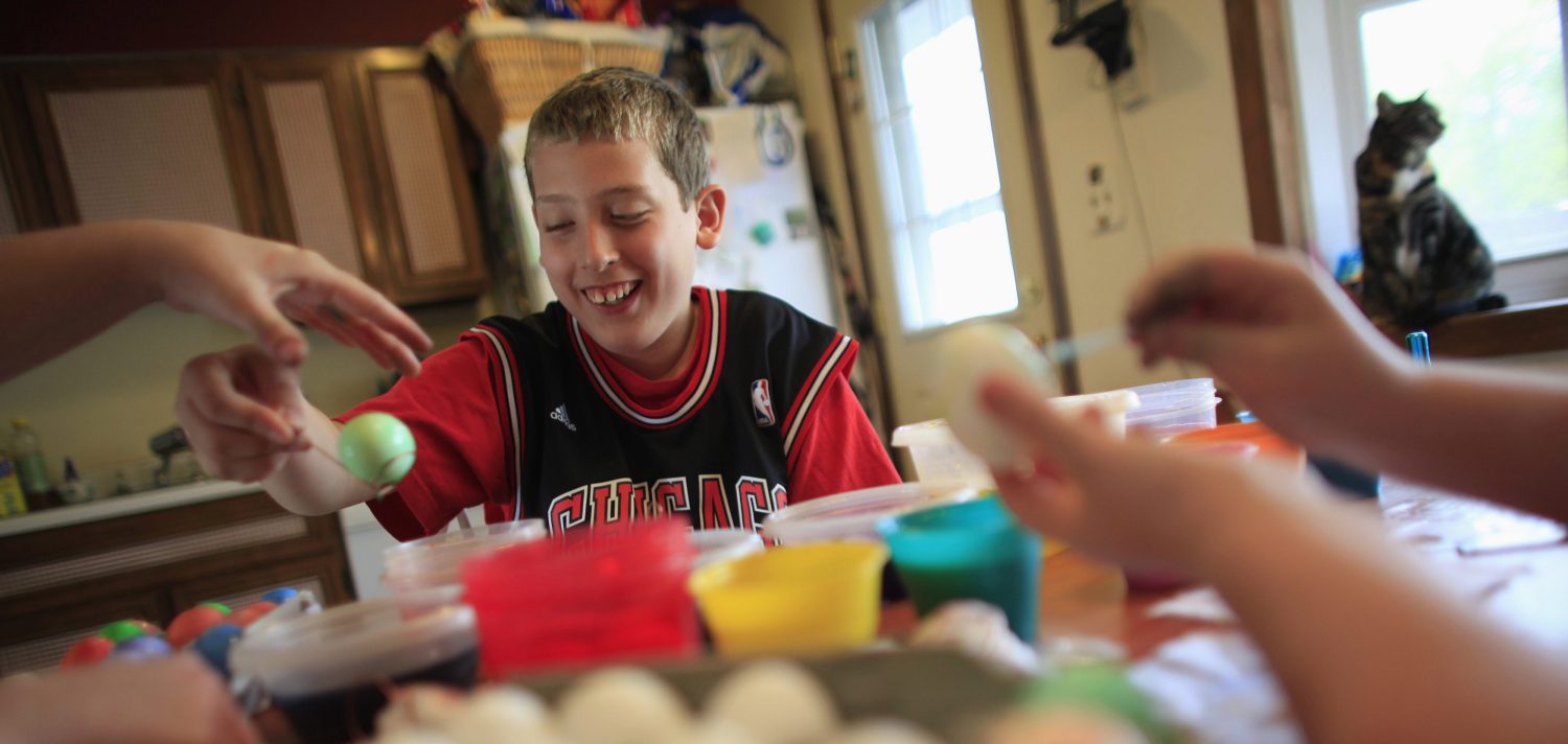 Parker Roos, who suffers from Fragile X, shares a laugh with his mother Holly and his sister Allison as they dye Easter eggs at their home in Canton, Illinois, April 4, 2012. Scientists and drug companies are in advanced trials with the first drugs expressly designed to correct problems underlying many forms of autism, offering new hope for families like Parker's. Picture taken April 4, 2012.