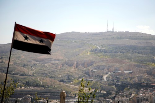A Syrian national flag flutters as Qasioun mountain is seen in the background from Damascus, Syria April 7, 2017. REUTERS/Omar Sanadiki - RTX34I6K