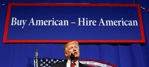 President Trump speaks in front of a "Buy American - Hire American" banner