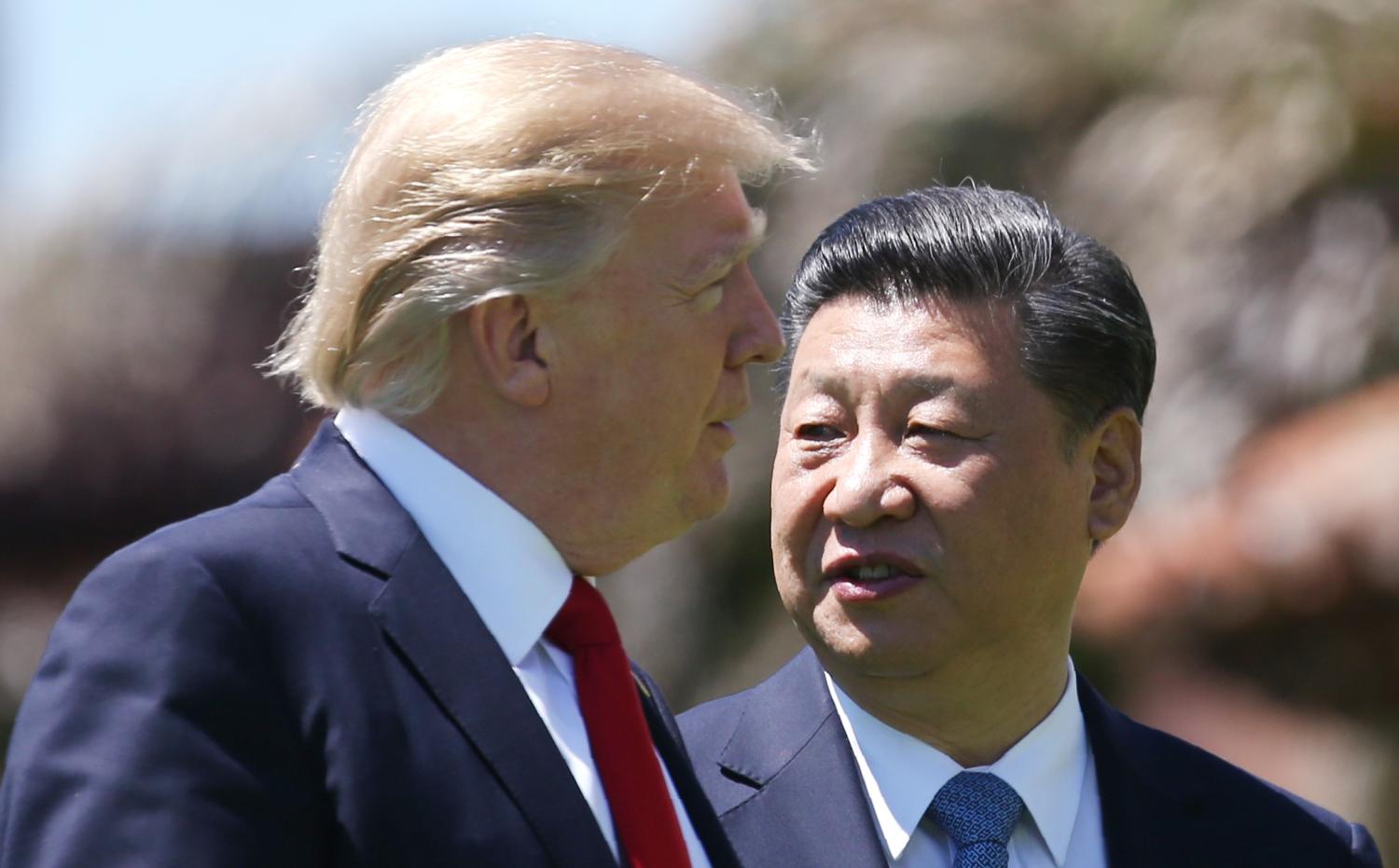 U.S. President Donald Trump (L) and China's President Xi Jinping walk along the front patio of the Mar-a-Lago estate after a bilateral meeting in Palm Beach, Florida, U.S., April 7, 2017. REUTERS/Carlos Barria - RTX34MG4