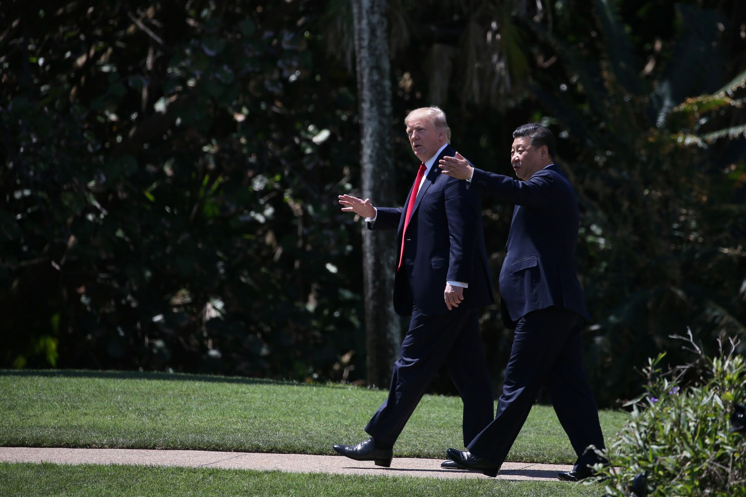 U.S. President Donald Trump and China's President Xi Jinping chat as they walk along the front patio of the Mar-a-Lago estate after a bilateral meeting in Palm Beach, Florida, U.S., April 7, 2017. REUTERS/Carlos Barria - RTX34M5B