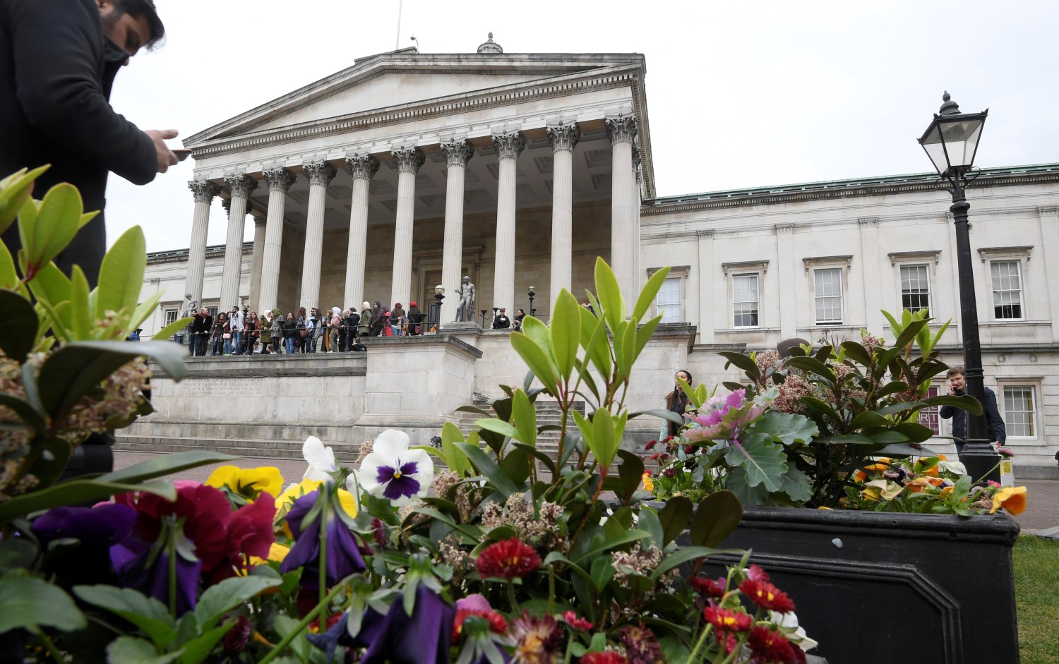Students and visitors are seen walking around the main campus buildings of University College London (UCL) in London, Britain