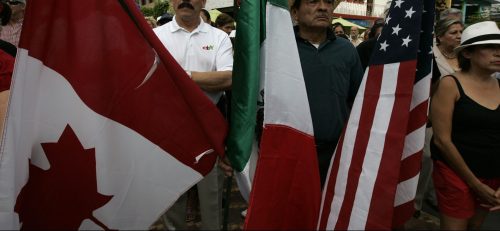 A resident holds the flags of Canada, Mexico and the U.S. during a meeting with local police officials in the town of Ajijic, in the Mexican State of Jalisco, May 16, 2012. About 400 U.S. and Canadian citizens gathered on Wednesday to meet with officials of the municipal police to demand for more security. Ajijic, on the shore of Chapala lake, is one of the populations with the highest number of foreigners residing in Mexico and has been plagued by kidnappings and vendettas between rival groups of drug trafficking in the past months, local media reported. REUTERS/Alejandro Acosta (MEXICO - Tags: CIVIL UNREST) - RTR326KB