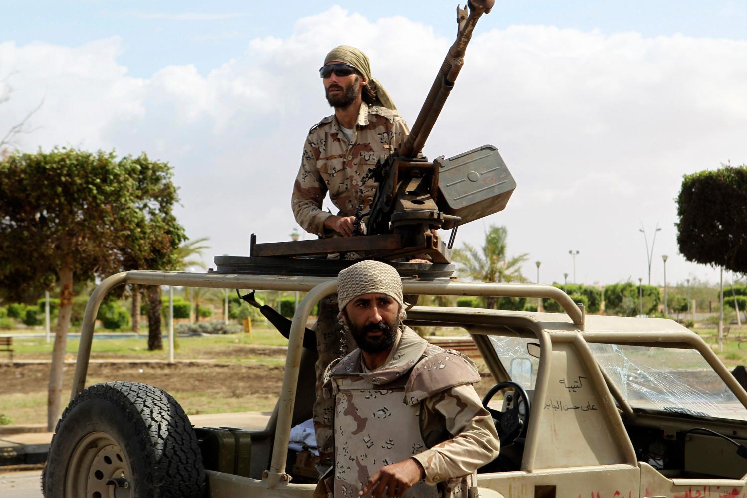 DATE IMPORTED:October 12, 2011Matthew Van Dyke (top), a U.S. citizen, fights alongside anti-Gaddafi fighters in Sirte October 11, 2011. NTC forces have captured Sirte's most important landmarks, including the Ouagadougou conference hall, where Gaddafi once hosted lavish summit meetings, the hospital and the university. Tuesday's fighting focused on Omar al-Mokhtar street, a tree-lined thoroughfare in a well-heeled neighbourhood. REUTERS/Asmaa Waguih (Libya - Tags: POLITICS CIVIL UNREST MILITARY CONFLICT)