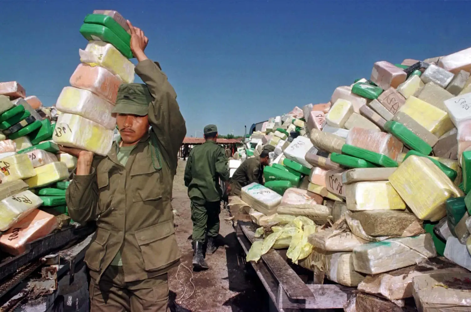 A soldier carries blocks of cocaine to a pile for incineration at a naval base in Matamoros, in Tamaulipas state April 29. Mexican authorities today burnt a 9,871kg haul of Colombian cocaine which was found inside a tanker truck heading for the United states last week. They also incinerated 3,891kg of marijuana. The near ten ton haul represents almost a third of Mexico's average annual cocaine seizures. - RTXHK4Z