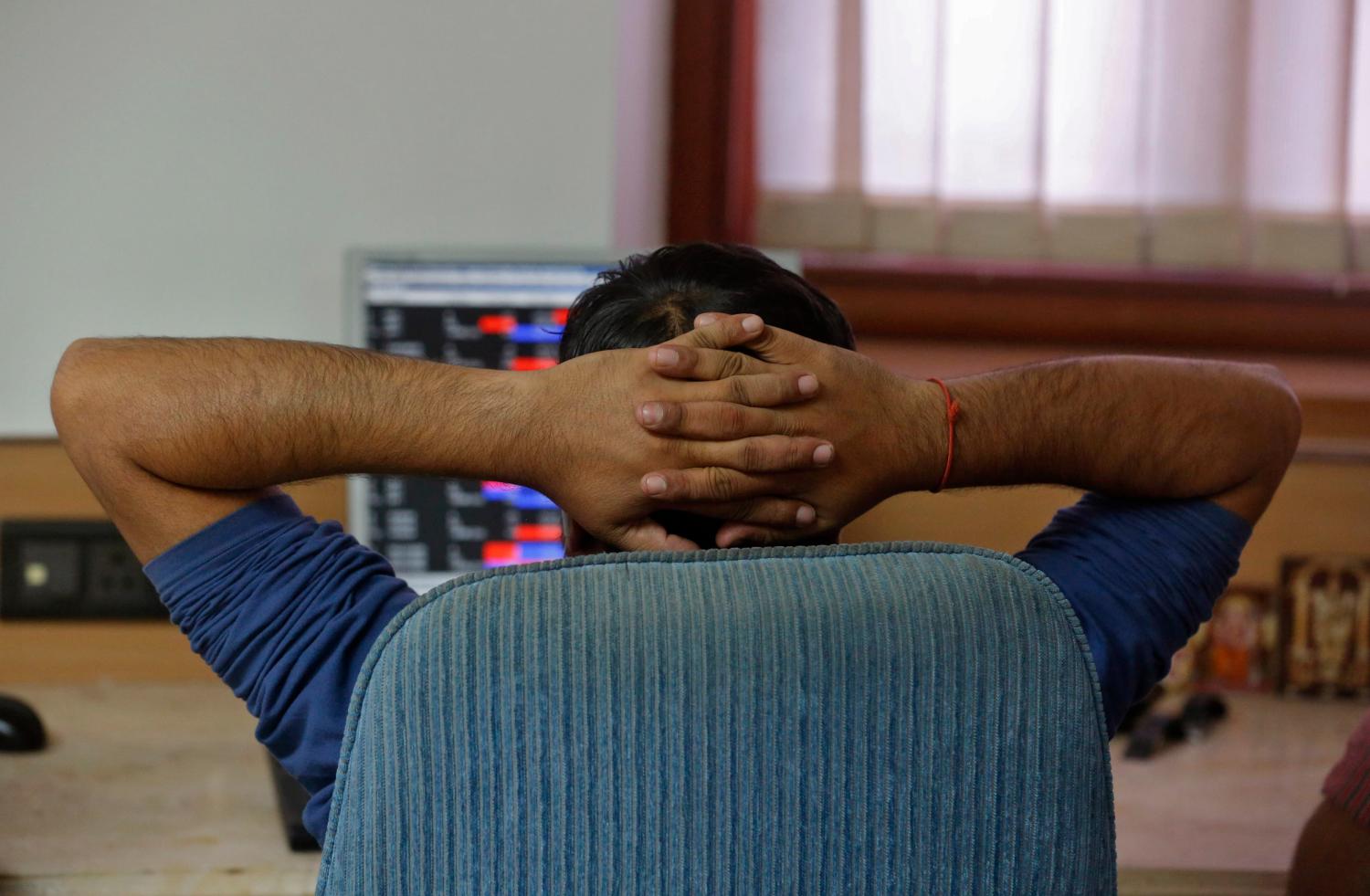 A broker reacts while trading at his computer terminal at a stock brokerage firm in Mumbai