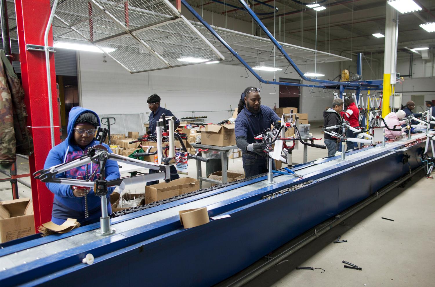 Workers operate the first assembly line started at the new Bicycle Corporation of America plant in Manning, South Carolina.