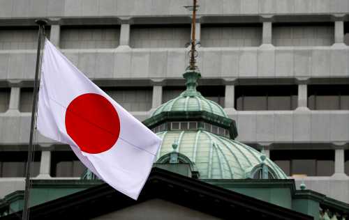 A Japanese flag flutters atop the Bank of Japan building.