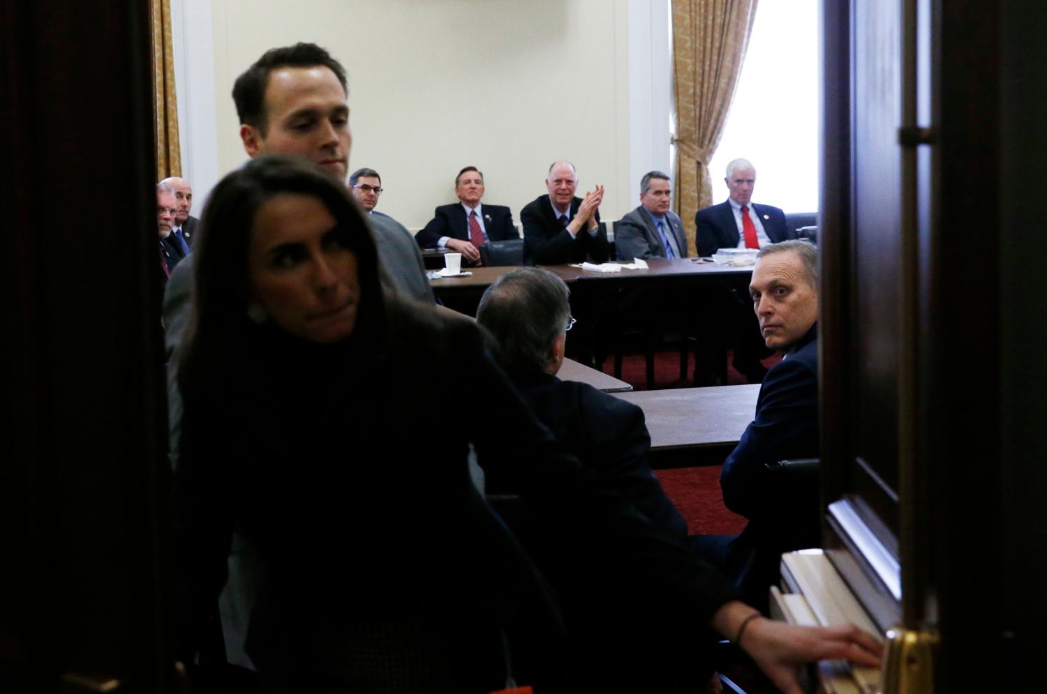 An aide opens the doors as members of the House Freedom Caucus meet on Capitol Hill after their meeting over healthcare legislation with President Donald Trump at the White House in Washington, U.S., March 23, 2017. REUTERS/Jonathan Ernst - RTX32FTU