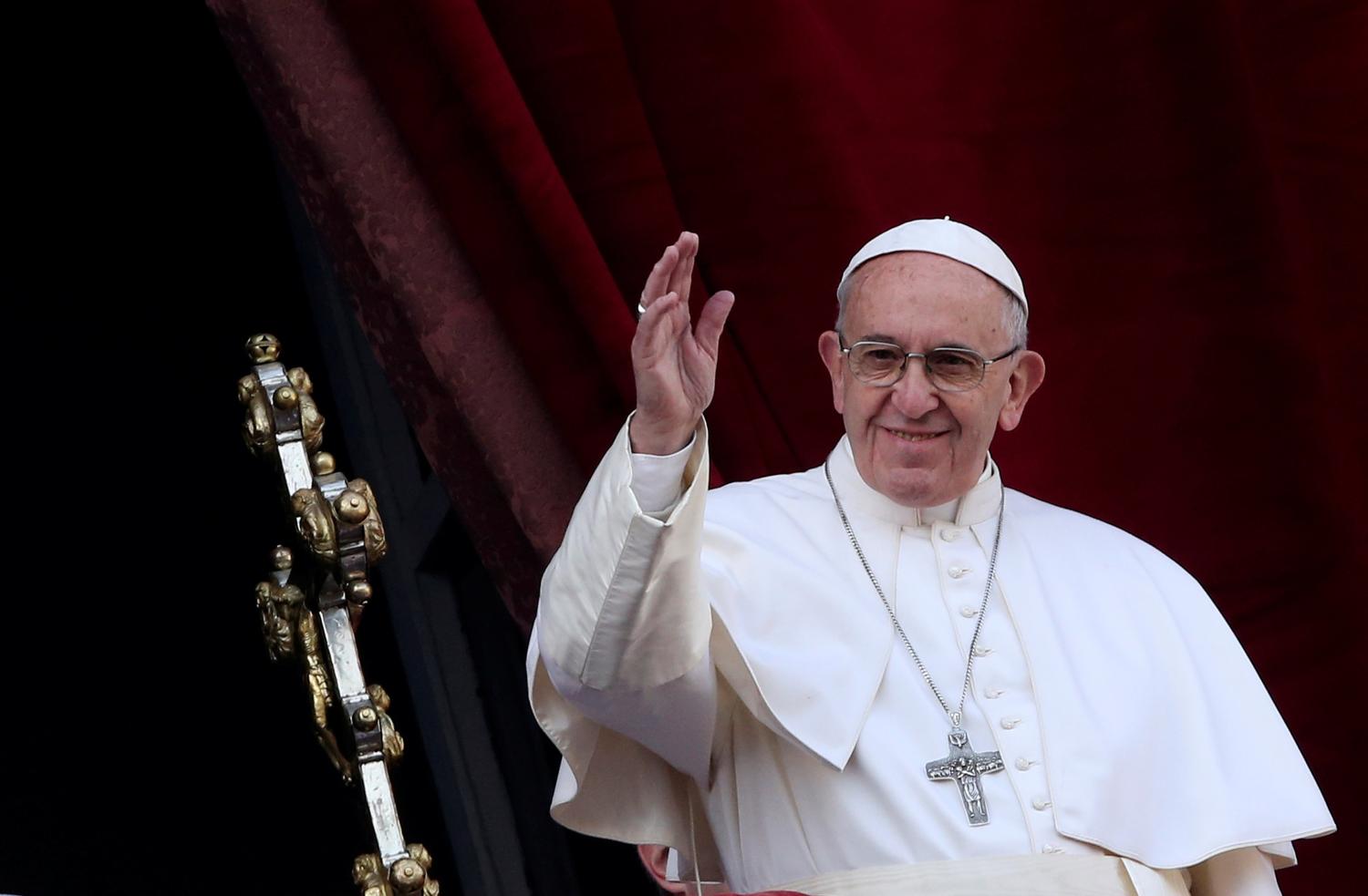 Pope Francis waves after delivering his "Urbi et Orbi" (to the city and the world) message from the balcony overlooking St. Peter's Square at the Vatican December 25, 2016. REUTERS/Alessandro Bianchi - RTX2WF55