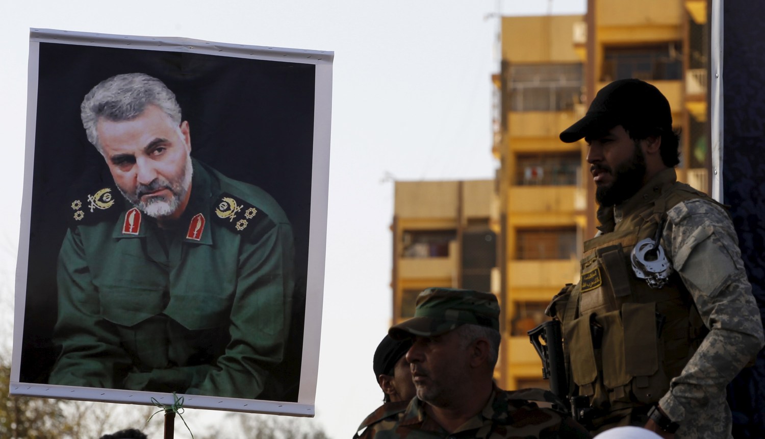 Members from Hashid Shaabi hold a portrait of Quds Force Commander Major General Qassem Suleimani during a demonstration in Baghdad to show support for Yemen's Shi'ite Houthis and in protest of the Saudi-led air campaign in Yemen .