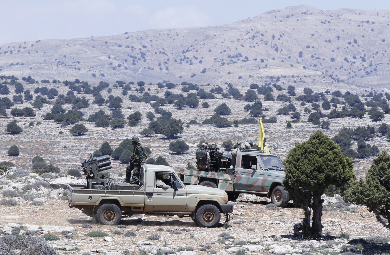 Lebanon's Hezbollah fighters sit on pick-up trucks mounted with weapons in Khashaat, in the Qalamoun region after they advanced in the area May 15, 2015. When Lebanon's Hezbollah first joined Syria's war on the side of President Bashar al-Assad, its role was a closely guarded secret. Today, as Hezbollah plants its flag in land won from rebels north of Damascus, its role could hardly be more public. Picture taken May 15, 2015. To match Insight MIDEAST-CRISIS/SYRIA REUTERS/Mohamed Azakir