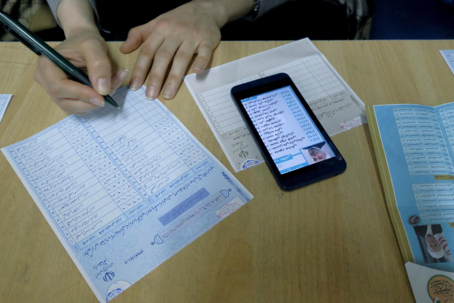 An Iranian woman fills in her ballot during elections for the parliament and a leadership body called the Assembly of Experts, which has the power to appoint and dismiss the supreme leader, in Tehran February 26, 2016. REUTERS/Raheb Homavandi/TIMA ATTENTION EDITORS - THIS IMAGE WAS PROVIDED BY A THIRD PARTY. FOR EDITORIAL USE ONLY. - RTX28SH7