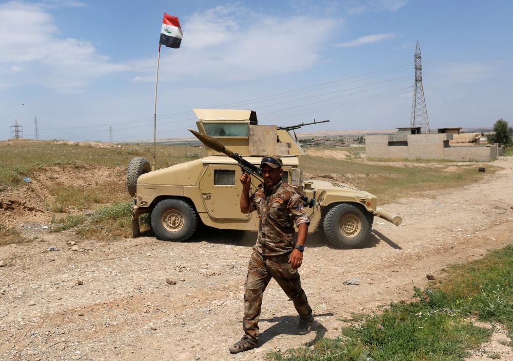 A member of Iraqi Army walks with his weapon during clashes with Islamic State fighters at a frontline, in north west of Mosul, Iraq, May 5, 2017. REUTERS/Danish Siddiqui - RTS15APH