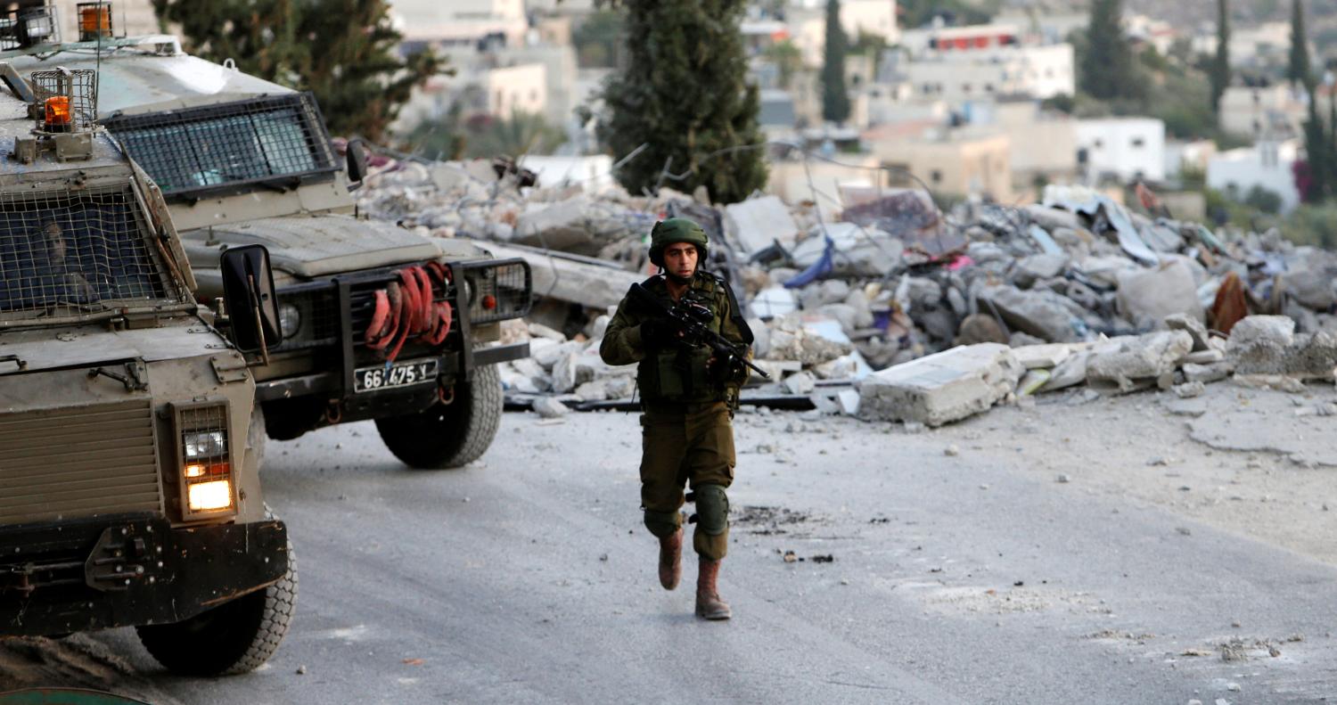 An Israeli soldier patrols near the house where Hamas fighter Mohammad al-Fakih was shot dead by Israeli troops during a raid in the West Bank village of Surif, near Hebron July 27, 2016. REUTERS/Mussa Qawasma - RTSJU39