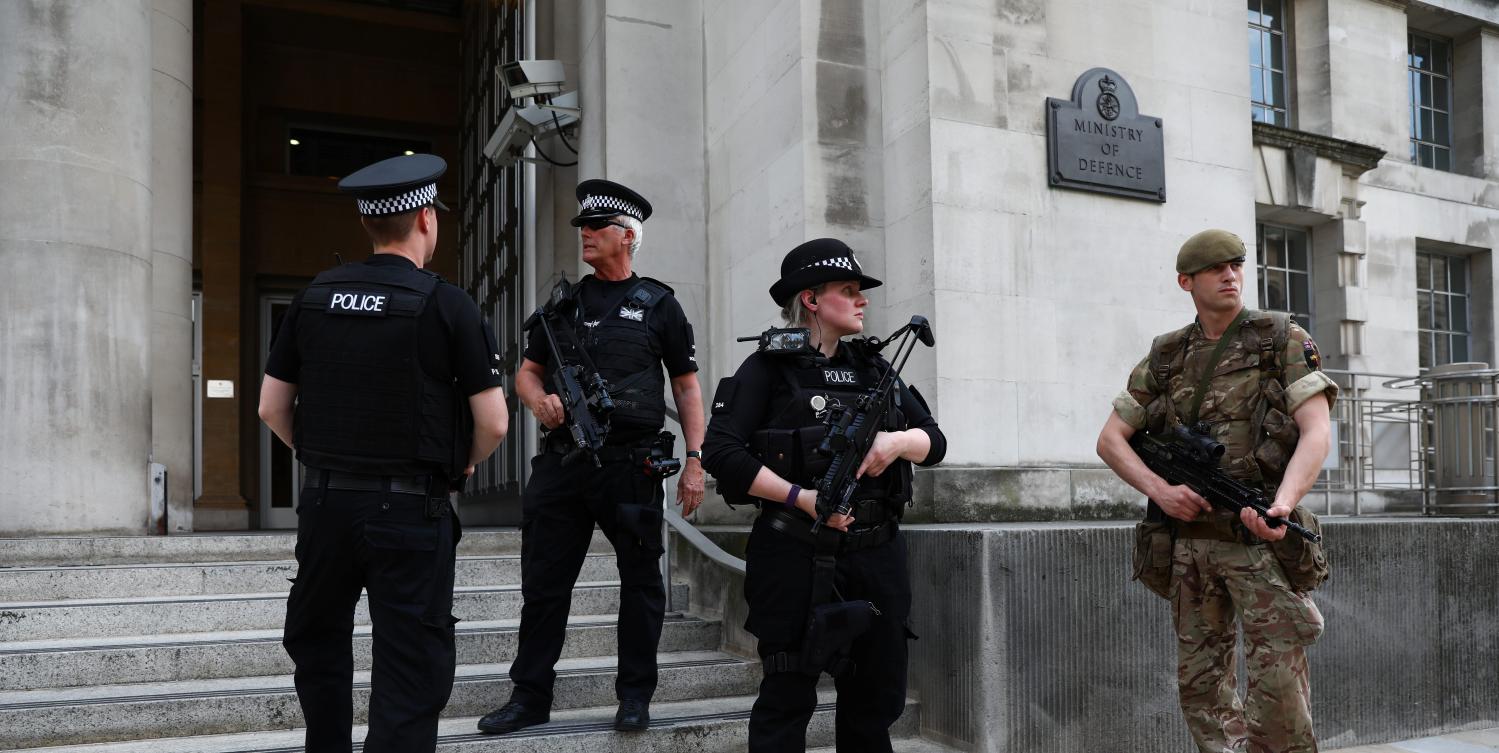 A soldier and police officers stand outside the Ministry of Defence in London, Britain May 24, 2017. REUTERS/Neil Hall - RTX37EHS