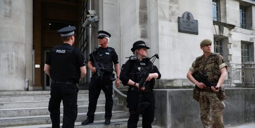 A soldier and police officers stand outside the Ministry of Defence in London, Britain May 24, 2017. REUTERS/Neil Hall - RTX37EHS