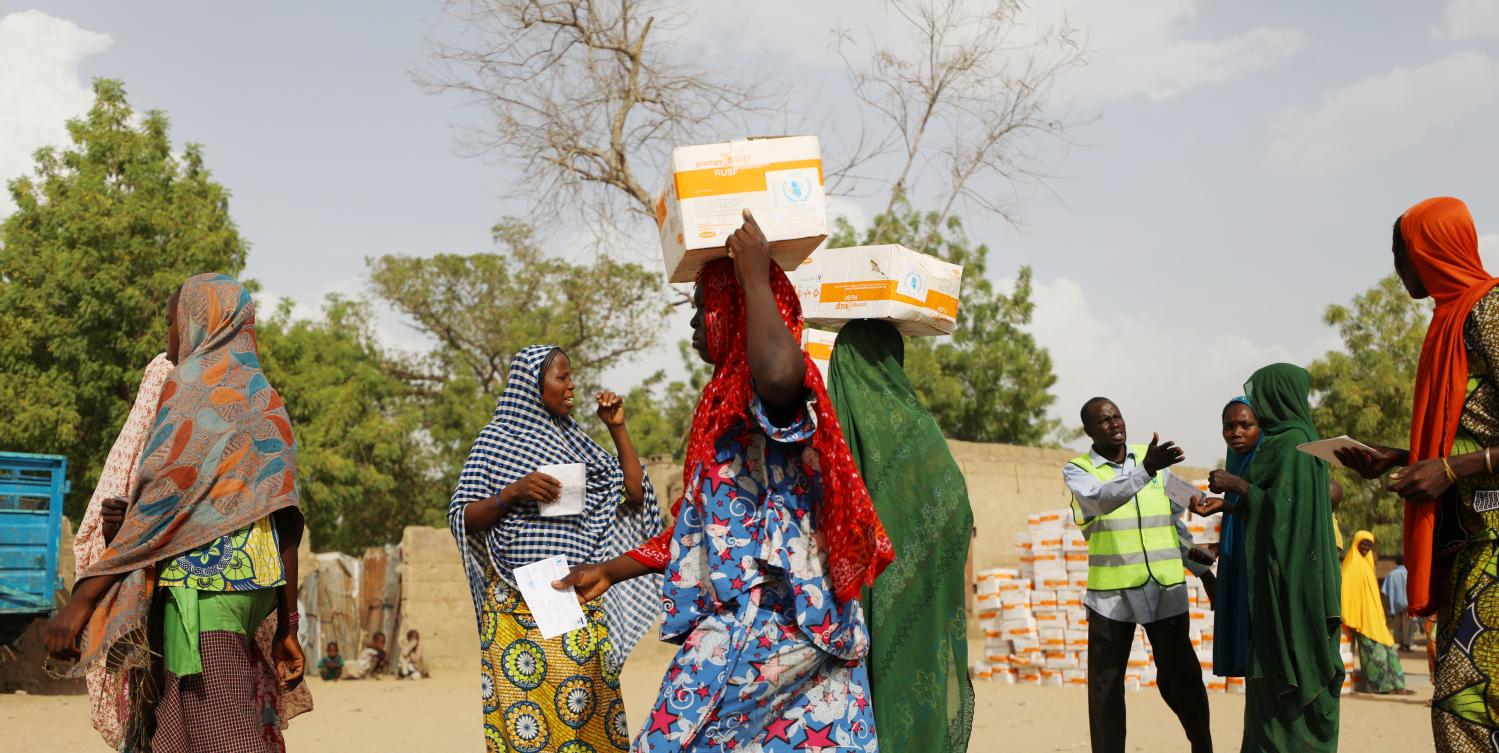 Women carry food supplement received from World Food Programme (WFP) at the Banki IDP camp, in Borno, Nigeria April 26, 2017. Picture taken April 26, 2017. REUTERS/Afolabi Sotunde - RTS14ZP0