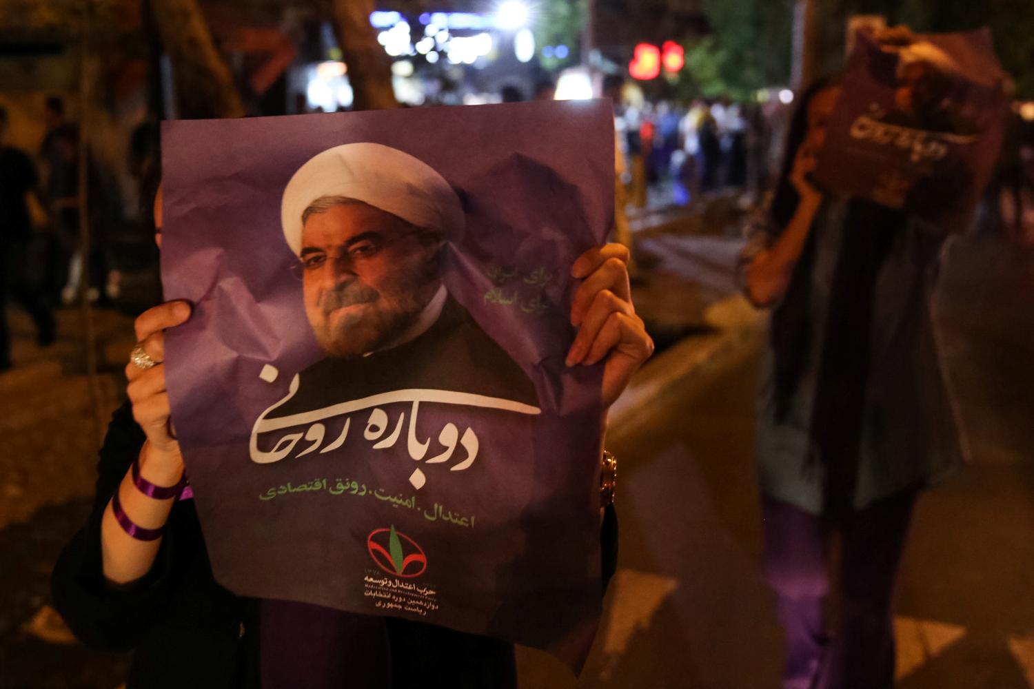 A supporter of Iranian president Hassan Rouhani holds his poster as she celebrates his victory in the presidential election, in Tehran, Iran, May 20, 2017. TIMA via REUTERS ATTENTION EDITORS - THIS IMAGE WAS PROVIDED BY A THIRD PARTY. FOR EDITORIAL USE ONLY. - RTX36R4M