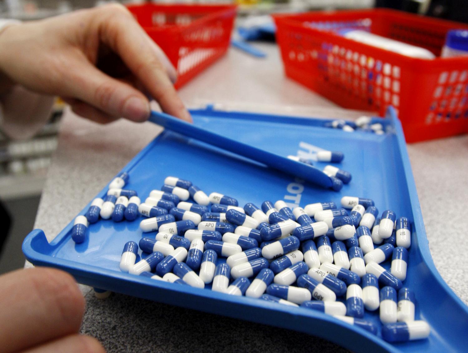 A pharmacist counts pills in a pharmacy