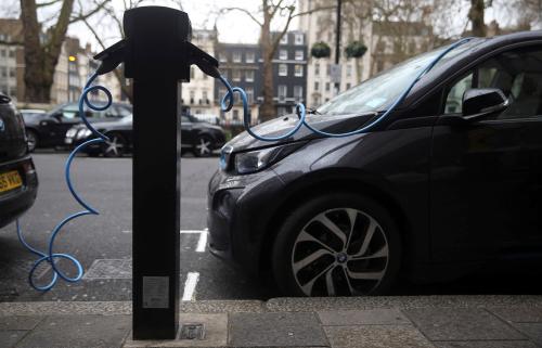 Electric cars are plugged into a charging point in London, Britain.